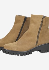 Suede tan ankle boots with black lug soles and side zippers on a white background.
