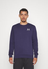Felpa blu navy realizzata in tessuto morbido, con maniche lunghe, collo rotondo e logo bianco di Under Armour sul petto.