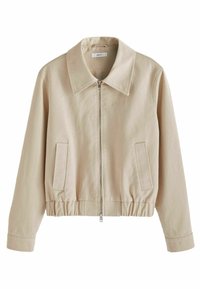 Veste cropped beige en toile, dotée d'un grand col, d'une fermeture éclair à l'avant, d'une taille élastique et de poches latérales.