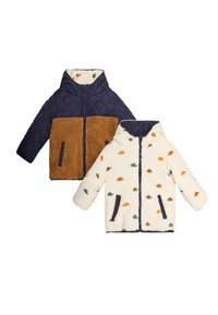 Giacca reversibile per bambini con un esterno trapuntato blu navy e un lato in sherpa marrone, o un lato ivorio con motivi di dinosauri colorati.
