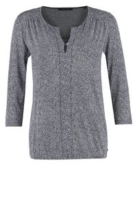 Langärmlige Bluse mit schwarz-weißem Muster, rundem Ausschnitt, vorderem Knopf-Schlitz und gerafften Stoffdetails.