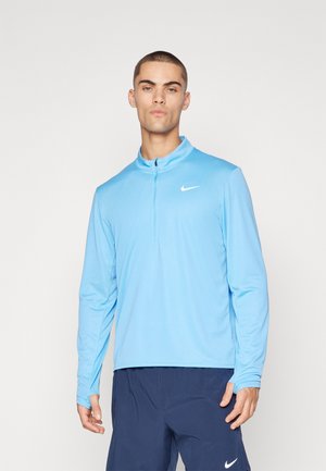 Light blue long-sleeve athletic shirt with a half-zip collar and Nike logo on the chest; features smooth, lightweight fabric with a relaxed fit.