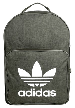 Sac à dos Adidas en tissu gris foncé avec un grand logo trèfle blanc et le nom de la marque sur la poche avant, fermeture éclair et poignée supérieure visibles.