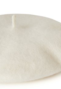 Witte vilt beret met een zachte textuur en een kleine, gecentreerde knoop aan de bovenkant. Het cirkelvormige ontwerp heeft een gladde, uniforme oppervlakte.