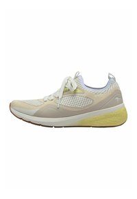 Zapatilla de running ligera en color crema, con parte superior de malla, collar acolchado y suela amarilla texturizada. Cordoneras y detalles en blanco.
