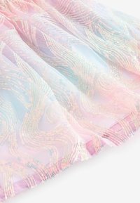 Rosa genomskinlig tyg med iriserande paljetter i vågmönster, med en mjuk textur och flödande design, kanterna invikta i matchande rosa.