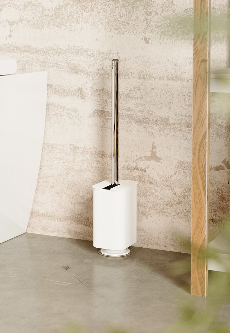 Porte-brosse de toilette blanc, de forme cylindrique et avec une poignée en chrome, doté d'un dessus fendu pour le rangement de la brosse, posé sur une surface lisse.