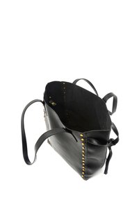 Black leather tote bag with gold studs along the edges, two handles, and an open top design. Interior is lined in a solid black texture.