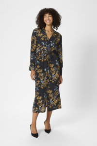 Long, black floral dress featuring blue and mustard yellow patterns, a collar, button-down front, and a fitted waist with a tie.