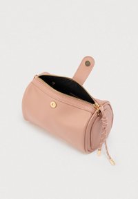 Στρογγυλή ροζ δερμάτινη τσάντα με χρυσλό φερμουάρ, μαύρο εσωτερικό και πλευρική λαβή. Διαθέτει διακοσμητικό κορδόνι με μεταλλικά άκρα.