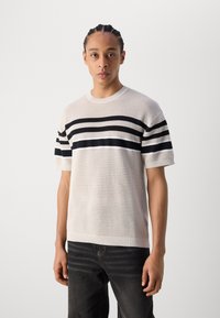 Kurzarm-Strickpullover in hellbeige mit schwarzen, weißen und dunkelblauen horizontalen Streifen. Verfügt über einen gerippten Halsausschnitt und Saum.