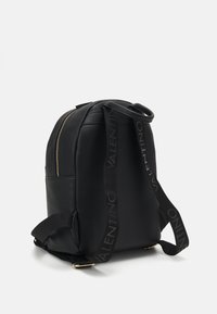 Black leather backpack with a textured finish, gold zipper, and adjustable black straps featuring the brand name in repeating pattern.