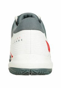 Scarpa sportiva bianca con un colletto testurizzato grigio, accenti rossi e una suola grigia con motivo. Presenta la scritta "QUIET RELEASE" sul tallone.