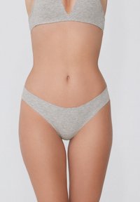 Lichtgrijze katoenen bralette en thongset met een naadloos ontwerp, zachte textuur en een minimalistische snit, die een comfortabele pasvorm biedt.