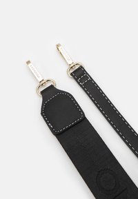 Två svarta väskremmar med vit sömnad och metallspännen i guldton med ingraverade "VALENTINO" på en vit bakgrund.