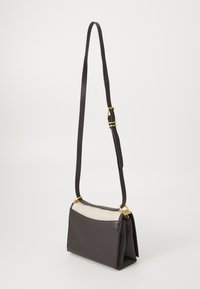 Borsa in pelle con un frontale grigio scuro e una parte superiore testurizzata color crema. Presenta un accento in metallo dorato e una tracolla regolabile.