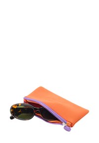 Okulary przeciwsłoneczne z ciemnymi soczewkami w częściowo otwartym pomarańczowym etui. Etui posiada fioletowy zamek błyskawiczny i tłoczone zdobienie. Miękka tekstura materiału.