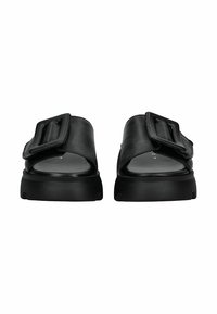 Sandales à glisser en cuir noir avec une large sangle, détail de boucle et semelle en caoutchouc noir épaisse. Texture lisse avec un design minimaliste.