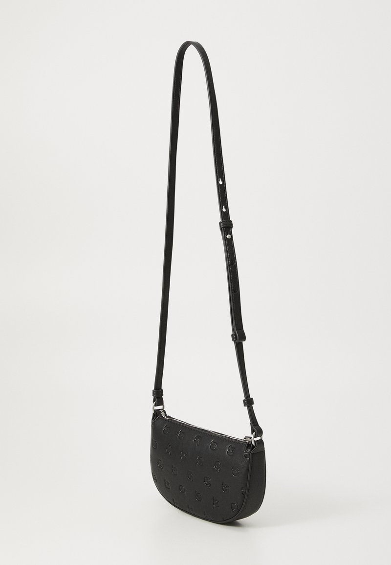 Sac bandoulière en cuir noir avec un motif de logo embossé, forme incurvée, bandoulière ajustable et fermeture éclair. Présente une texture lisse avec des accents métalliques.