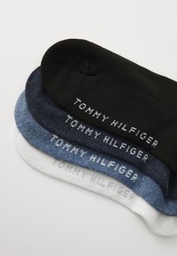 Tri par sokov v črni, temno modri, svetlo modri in beli barvi; mehak material z vžgano "TOMMY HILFIGER" oznako v beli barvi na vsakem paru.