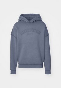 Sweat-shirt à capuche en bleu pâle, fabriqué en tissu doux, avec un logo brodé "Alpha Industries" sur la poitrine et des poignets et un ourlet côtelés.