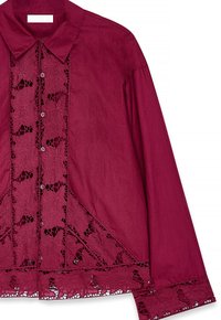 Blusa bordeaux con maniche lunghe, colletto, dettagli in pizzo floreale, chiusura con bottoni e tessuto testurizzato. Bordo in pizzo all'orlo e sul davanti.
