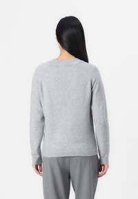 Grau gestrickter Pullover mit rundem Halsausschnitt und Raglanärmeln, ausgestattet mit ribbenförmigem Saum und Bündchen, aus weichem, strukturiertem Stoff gefertigt.