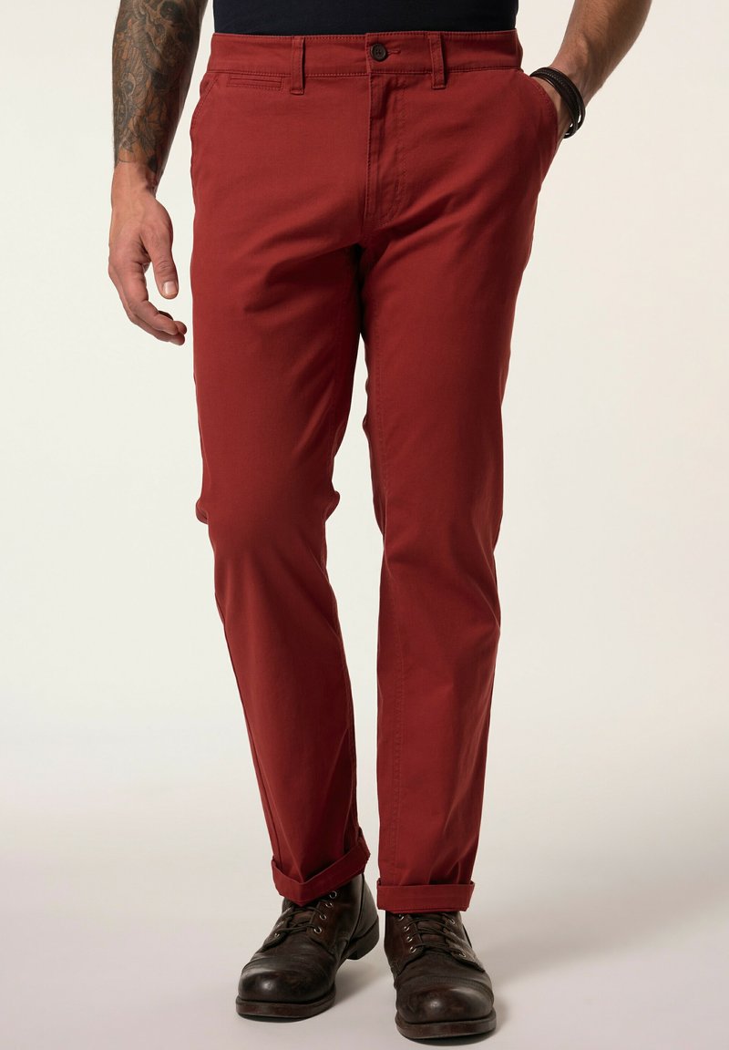 Pantaloni rossi in cotone con una vestibilità slim, dotati di chiusura con bottone e cerniera, tasche frontali e orli risvoltati. Texture robusta.