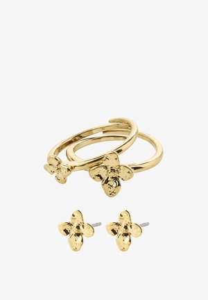Deux boucles d'oreilles créoles en or et des clous d'oreilles assortis en forme de fleur en or avec des pétales texturés sur fond blanc.