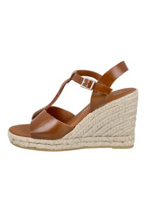 Sandalia de cuña de charol marrón con tira en T y hebilla en el tobillo, con suela plataforma de yute trenzado.