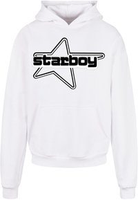 Felpa bianca con un grafico a forma di stella nera e il testo "starboy" in grassetto. Il design include una tasca a marsupio frontale e polsini a costine.
