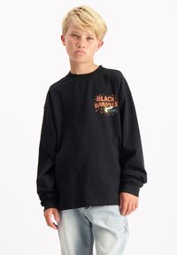 Zwart langarm T-shirt van katoen met een ronde hals. Voorzien van een kleurrijke print met de tekst "BLACK BANANAS" op de borst.