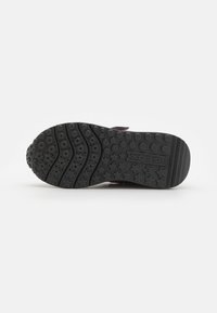 Semelle de chaussure en caoutchouc noir avec un grip texturé, arborant des motifs circulaires et en étoile. Des rainures flexibles améliorent l'adhérence et le confort.