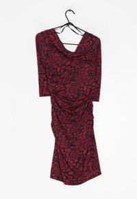 Robe à motifs rouges et noirs avec un décolleté drapé, des manches trois quarts et des détails froncés sur un côté. Texture de tissu lisse.