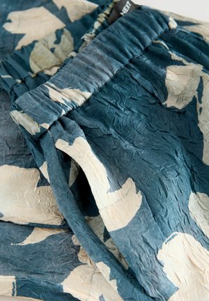 Lehká, pomačkaná sukňa v teal barvě s béžovým abstraktním květinovým vzorem; elastický pás; jemná textura; casual design.