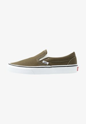 Zapatos Vans slip-on en lona verde oliva. Suela de goma blanca con borde negro. Interior forrado con detalles elásticos en los laterales para facilitar su uso.