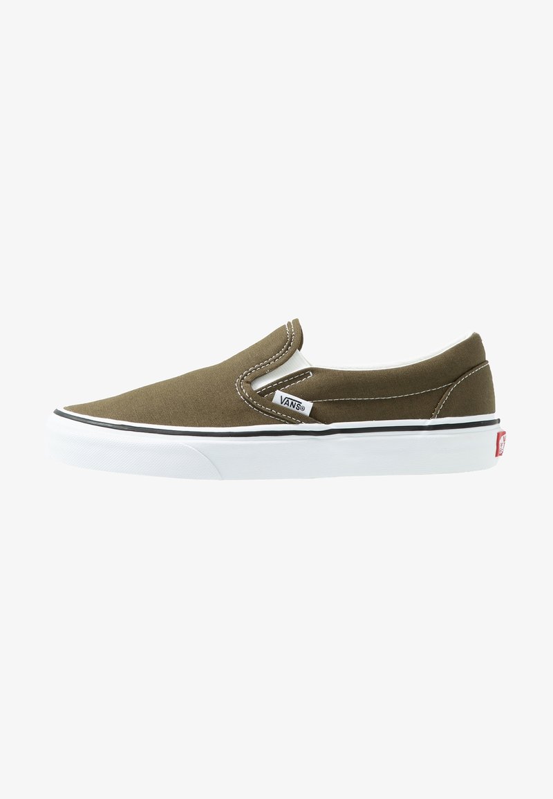 Chaussures Vans slip-on en toile vert olive. Semelle en caoutchouc blanche avec une bordure noire. Intérieur doublé avec des accents élastiques sur les côtés pour un enfilage facile.