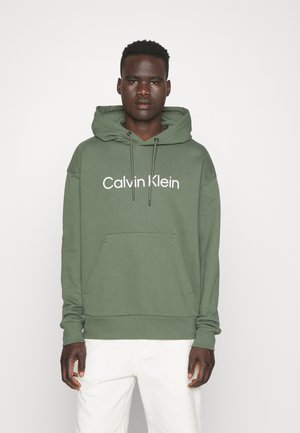 Felpa verde in cotone con tasca frontale, cappuccio con cordino e logo bianco "Calvin Klein" sul petto. Vestibilità standard con polsini a costine.