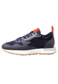 Navy blue sneaker with leather and suede panels, blue laces, white sole, gum tread, and orange accents on tongue and heel tab.