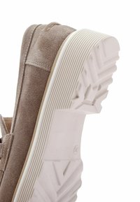 Scarpa in suede marrone con tomaia strutturata, suola piatta in gomma bianca e motivo a zigzag per la trazione sul fondo.