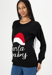 Black sweater with a large red and white Santa hat design and "Santa Baby" in white text, featuring ribbed cuffs and hem.