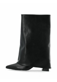 Bottine en cuir noir avec une silhouette allongée et drapée. Présente un bout pointu et un talon bas et carrément. Texture lisse sur l'ensemble.