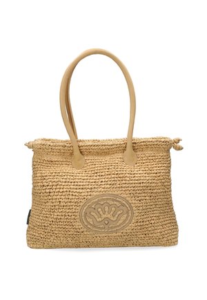 Woven straw handbag in tan with a smooth leather logo patch, dual handles, and a rounded shape. Features decorative knot details on the ends.