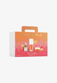 Zestaw prezentowy w pomarańczowym kolorze z uchwytem, zawierający trzy produkty do pielęgnacji skóry: buteleczkę z pipetą, butelkę z pompką oraz mały słoik. Tekst podkreśla korzyści.