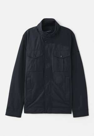 Marineblaues Jacket mit strukturiertem Kragen, Druckknopfverschluss, zwei Brusttaschen und einer weichen, matten Oberfläche. Entworfen für Funktionalität und Komfort.