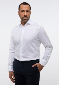 Witte lange mouwen shirt met een slim fit, button-down kraag en gouden knopen. Glad stoftextuur, gecombineerd met donkere broek.