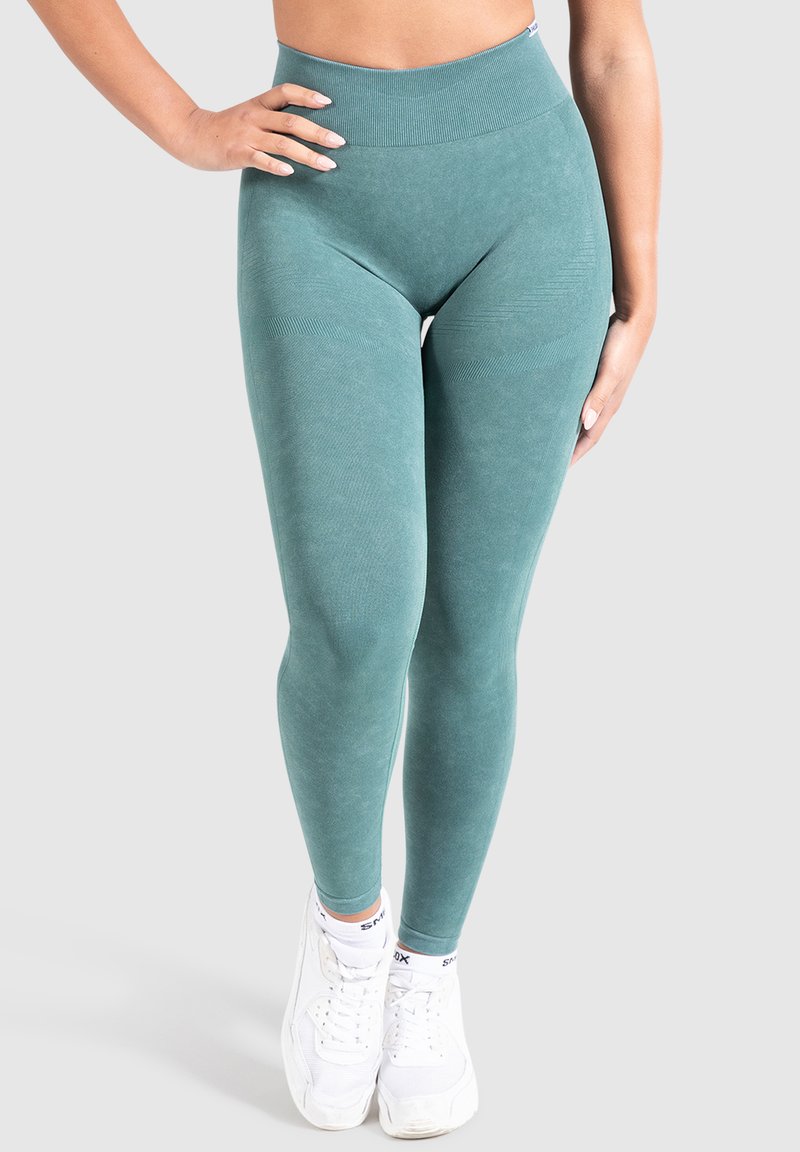 Leggings teal a vita alta in un morbido materiale testurizzato, con design senza cuciture e sottili dettagli a coste in vita e ginocchia.