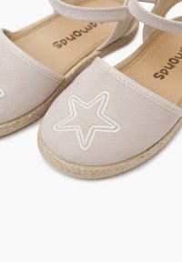 Lichtbeige espadrilles met een canvas bovenzijde, voorzien van een witte sterrenborduursel. Jute-wikkelde zool en enkelband voor een stevige pasvorm.