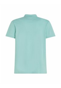Polo shirt di un azzurro chiaro con colletto a coste e maniche corte. Texture liscia e design semplice, privo di loghi o motivi visibili.