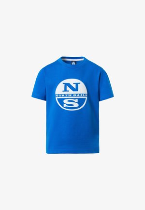 Niebieski bawełniany t-shirt z białym logo "NORTH SAILS", zestawiony z granatowymi spodniami cargo z kieszeniami bocznymi oraz białymi trampkami.